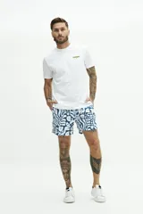 Short de baño azul con estampado de hojas blancas, cintura elástica con cordón ajustable, dos bolsillos laterales y un bolsillo trasero.