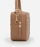 Bolso camera bag transversal mediano color beige, con cierre de cremallera, correa de mano y asa larga con detalle de cadenas desmontables.