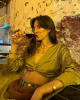 Collar con dije irregular dorado y cordón marrón ajustable.