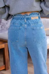 Pantalón de jean celeste de corte babucha con lazo ajustable en la cintura.