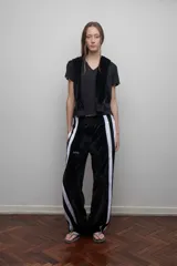 Pantalón de terciopelo negro con bandas laterales blancas, cintura elástica y botamanga recta.