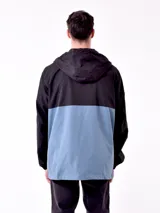 Campera con capucha azul marino y beige con cierre frontal y logo en el pecho.