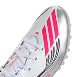 Championes de fútbol 5 Adidas F50 Messi Club TF, unisex, color blanco con detalles en negro y rosa. Inspirados en Lionel Messi, con suela Turf (TF) para canchas sintéticas y exterior sintético ligero y resistente.