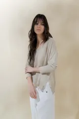 Sweater color beige de tejido de punto con brillo, escote en V y mangas largas.