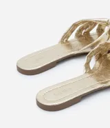 Sandalia plana mule metalizada con puntera cuadrada y tiras cruzadas con efecto crepitante.