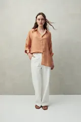 Camisa estampada con figuras geométricas en tonos azul, marrón y beige. Corte relajado, manga tres cuartos y botones al frente.