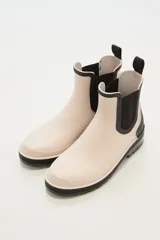 Botas de lluvia bajas color beige con elástico lateral negro y suela de goma negra.