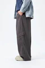 Pantalón cargo color beige, de corte recto y holgado, con cintura elástica y bolsillos laterales con solapa.