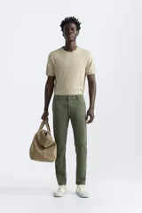 Pantalón chino azul marino, corte skinny fit, confeccionado en tejido de algodón con elasticidad. Cuenta con bolsillos frontales y traseros de vivo. Cierre frontal con cremallera y botón.