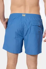 Short de baño azul vibrante, de corte clásico y largo medio, con cintura elástica y cordón ajustable. Cuenta con bolsillos laterales y suspensor de malla fina interior.