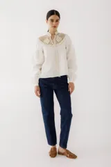 Blusa negra con cuello de crochet hecho a mano, cuerpo de lino y mangas amplias que se ajustan al puño.