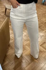 Pantalón de jean blanco con corte recto y apliques de strass plateados.