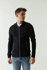 Campera gris de felpa con capucha, cierre frontal, bolsillos laterales con cierre, puños elásticos y logo bordado en el pecho.