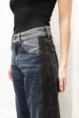 Pantalón de jean gris de corte recto y tiro medio, con bordado de estrella de ocho puntas en los bolsillos traseros.