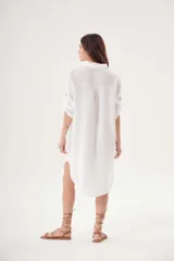 Vestido camisero blanco de lino, con cuello clásico, cierre frontal con botones y mangas 3/4 con trabillas.