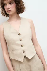 Chaleco sastre color amarillo mostaza, confeccionado en lino con forro de algodón y cierre frontal con botones.