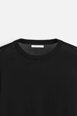 Jersey negro de lana con acabado mercerizado, corte relaxed fit, cuello redondo y manga larga con terminaciones en rib.