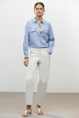 Pantalón de jean color crudo, de tiro medio, corte tapered, con cinco bolsillos y raya planchada en el frente.