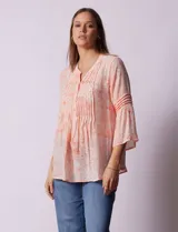Blusa de gasa estampada color salmón con flores blancas, marca Ruby Rd. Cuello a la base, escote en V y abertura central con botones. Delantera con plisados. Largo de manga ¾ con terminación amplia.
