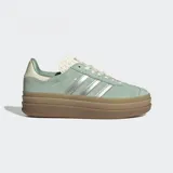 Championes Adidas Gazelle Bold color verde agua con detalles plateados y suela de plataforma marrón. Confeccionados en gamuza, cuero y material sintético.