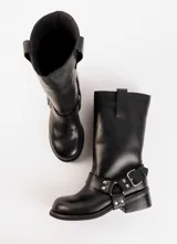 Bota de cuero marrón oscuro con caña media, estribo desmontable y hebilla metálica. Taco de madera de 5cm y suela de caucho.