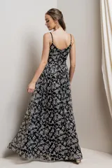 Vestido largo de fiesta negro con breteles finos y escote en V. Tiene un estampado floral plateado y falda amplia de tul.