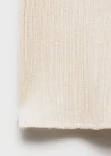 Pantalón largo de punto de canalé color crema, con cintura elástica, corte flare y tejido fino.