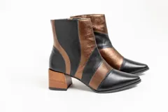 Botas cortas de cuero negro y bronce, con punta fina, cierre lateral y taco de madera.