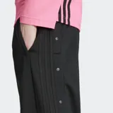 Pantalón deportivo Adidas Adibreak negro con logo de Adidas en la pierna. Tiene cintura elástica con cordón ajustable, bolsillos laterales y botones a presión a los lados.