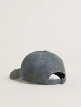 Gorra de béisbol de denim celeste con efecto desgastado. Tiene bordado en el frente el texto "Golden University" en color blanco.