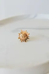 Anillo dorado con forma de sol con rostro, ajustable entre 16mm y 19mm.