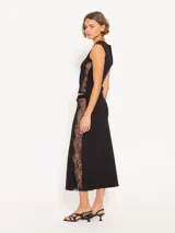 Pollera midi negra ajustada al cuerpo, con elástico en la cintura y recortes laterales de encaje.