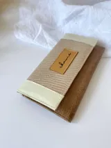 Billetera beige, crema y marrón con cierre de broche y monedero externo.