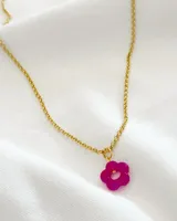 Collar dorado con dije de flor fucsia.