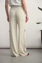 Pantalón cargo color verde oliva, de corte ancho, con bolsillos laterales con solapa y cintura con cordón ajustable.