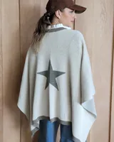 Ruana negra de tejido de punto con una estrella grande color beige en la espalda y borde inferior con franja beige.