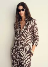 Camisa de manga larga con estampado abstracto en tonos marrones y blancos, cuello camisero y cierre frontal con botones.