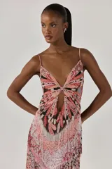 Vestido largo ajustado sin mangas, forrado de tul. Presenta un estampado exclusivo, bordado de cuentas en el busto y el corpiño, abertura en el centro delantero, flecos de cuentas, tirantes finos cruzados y cierre de cremallera invisible en la espalda.