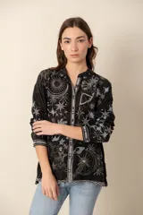 Camisa negra con bordados de motivos celestiales, de seda con botones forrados.