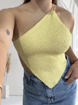 Top amarillo pastel tejido al crochet, con diseño asimétrico y un solo tirante.