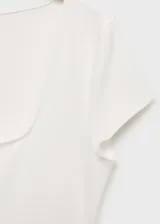 Camiseta blanca con cuello cuadrado, mangas cortas y corte crop con peplum. Jeans de tiro alto color azul oscuro.