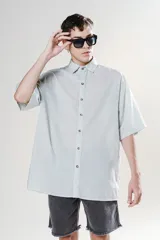 Camisa celeste de manga corta con calce oversize y canesú en la espalda.