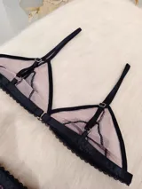 Conjunto de lencería de microtul color tostado con detalles de encaje negro. Incluye corpiño triangular con breteles finos regulables y tanga regulable de elástico ancho.