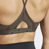 Sostén deportivo Adidas de soporte ligero, color verde oliva, con tiras delgadas ajustables en la espalda y logo pequeño en el frente. Cuenta con almohadillas removibles.