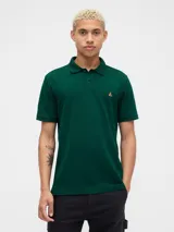 Remera polo verde oscuro para hombre, con cuello y mangas cortas. Presenta un pequeño bordado de un oso en el pecho.