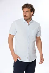 Camisa celeste y blanca a rayas verticales, de lino y algodón, manga corta, corte slim fit, con cuello abotonado y bolsillo en el pecho.