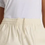 Pantalón cargo color crema, de corte recto, con cintura elástica ajustable con cordón, bolsillos laterales y tobillos ajustables con broches.