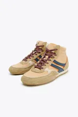 Zapatilla deportiva tipo botín color beige con detalles en azul marino y naranja.