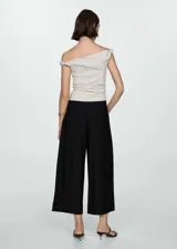 Pantalón negro de corte ancho con tablas, tejido fluido y largo hasta el tobillo.