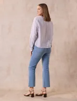Blusa de algodón a rayas verticales finas en tonos lila y blanco, marca Dash. Escote en V y abertura frontal con botones. Mangas largas regulables con presilla y botón. Terminación de ruedo anudado.
